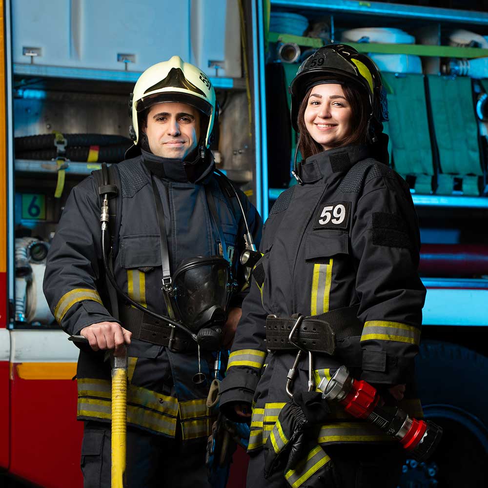 Bild eines glücklichen Feuerwehrmanns und einer glücklichen Frau in der Nähe eines Feuerwehrautos